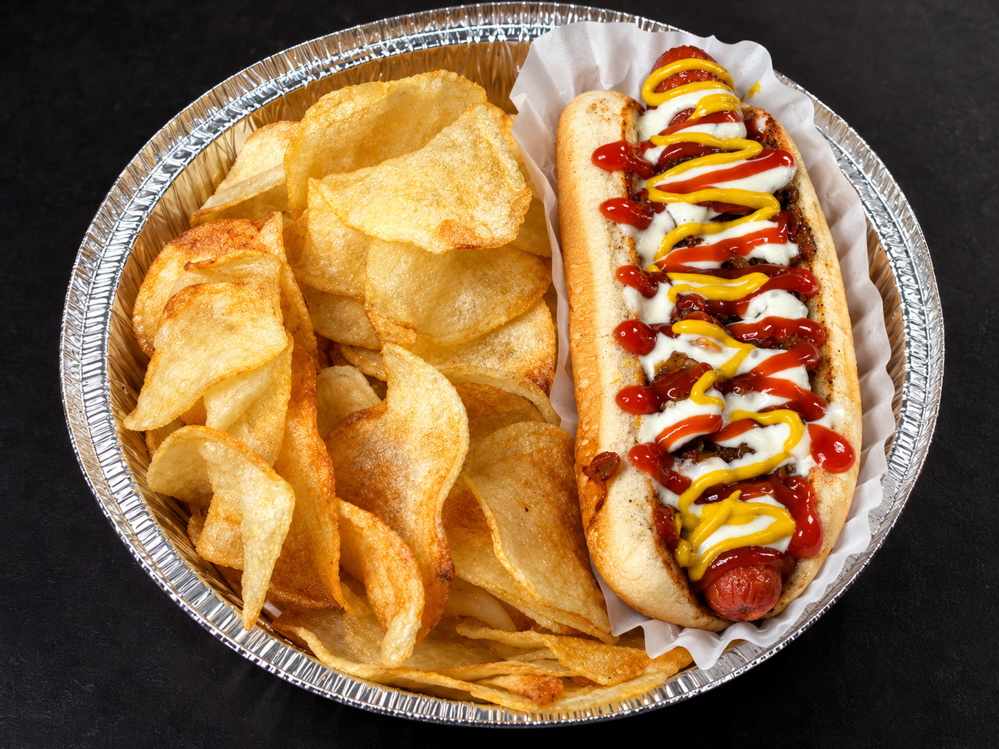 Beef hot dog with onion, ketchup, mayonnaise, mustard, and potato chips at Floritas Delicias Latinas in East Orange, NJ.